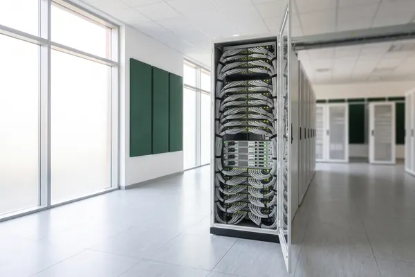 Bright server room with an open server rack and green status LEDs